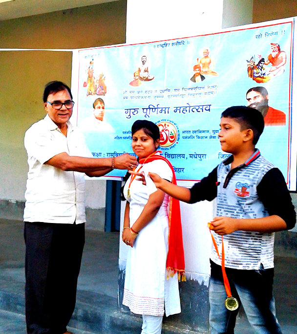 The Popular Professor of Physics Dr.B.N.Yadav Madhepuri encouraging Patanjali Yoga Teacher Miss Ruby Kumari by giving a medal for her best performance on the occasion of Guru Purnima Mahotsav at Rasbihari High School, Madhepura.